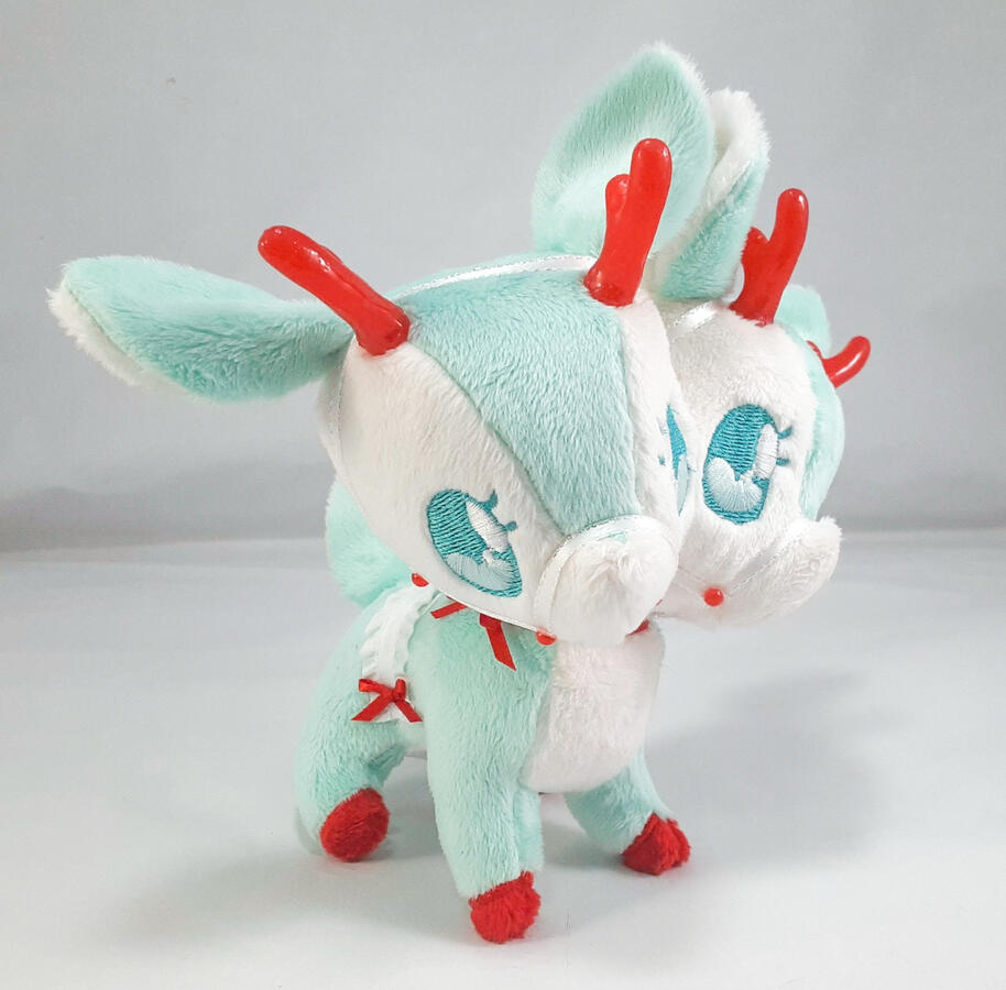 A mint green two-headed reindeer plush with red accents