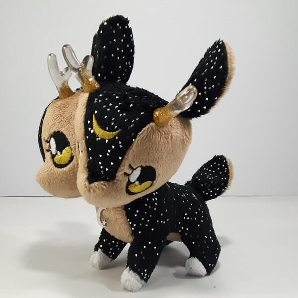 A sparkling black two-headed deer plush with gold accents and clear horns